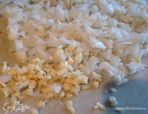 Очистите и мелко нарежьте лук и чеснок. В кастрюлю с толстым дном налейте растительное масло и обжарьте лук и чеснок.