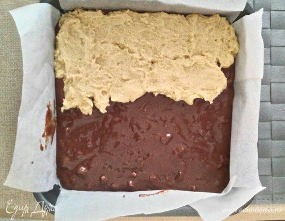 Добавить муку и разрыхлитель. Замесить тесто. Затем, небольшими порциями, отщипывать тесто и выкладывать его на брауни. Сильно не нажимать. 