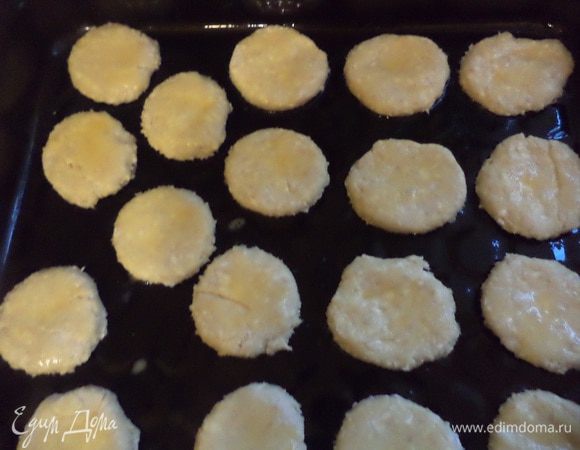 Колбаски нарезать кружочками толщиной 3 - 4 мм, выложить на противень и смазать желтком.
