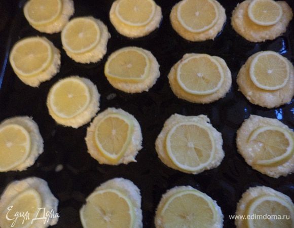 Лимоны тщательно вымыть, вытереть насухо полотенцем и нарезать на очень тонкие дольки.
Лимонные дольки выложить сверху на печенье, посыпать крупным сахаром. 
Выпекать при температуре 180 градусов 12 - 15 минут.
