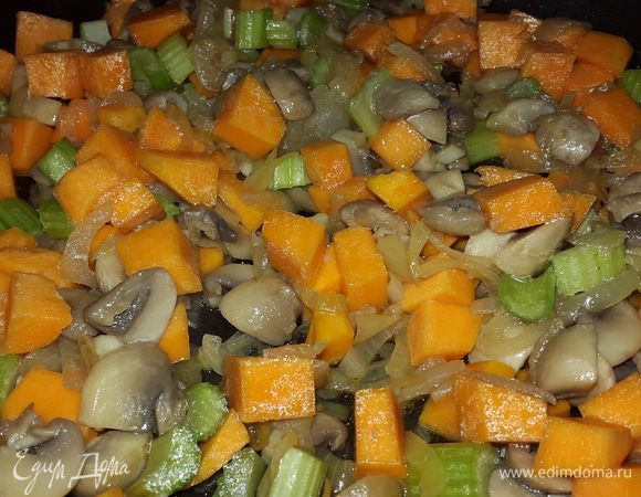 Параллельно режем тыкву и сельдерей на кубики, отправляем их к луку и грибам, перемешиваем, убавляем огонь до минимума и тушим, помешивая.