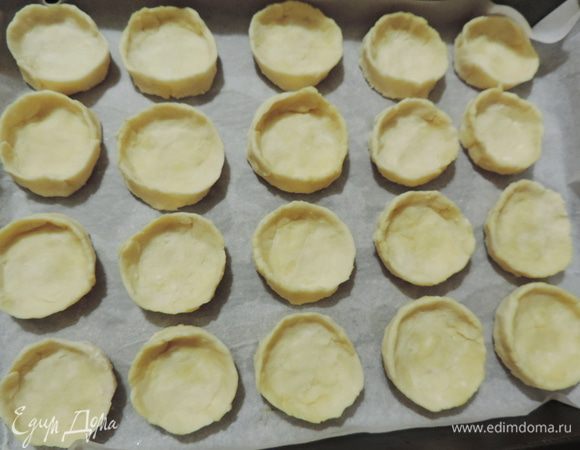Тесто разделить на шарики размером с грецкий орех. Каждый шарик расплющить пальцами так, чтоб получить «тарелочку» с бортиками. Выложить печенье на противень, застеленный пергаментом.