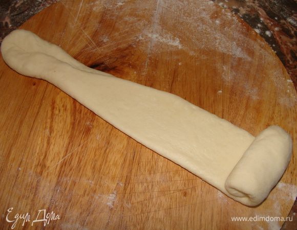 Отщипываем от теста шарик, размером с шарик для большого тенниса. На подпыленном столе раскатываем длинный жгут. Оставшееся сливочное мало растопить. Смазать жгут из теста сливочным маслом с помощью силиконовой кисти.