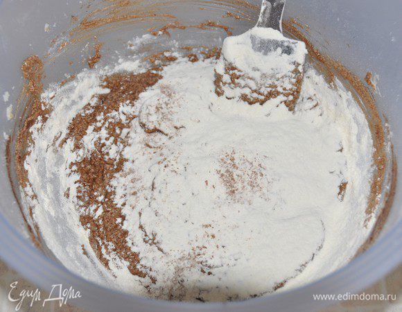 Влить в тесто половину какао. Размешать. Добавить половину нормы просеянной муки с содой и разрыхлителем. Перемешать медленно и недолго, только до объединения. 
