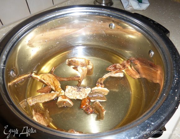 Наливаем в кастрюлю небольшое количество воды и засыпаем сухие грибы - у меня белые. Ставим кастрюлю на плиту и ждем, когда вода закипит, отвариваем грибы 10 -15 минут и даем хотя бы минут 30 бульону настояться.