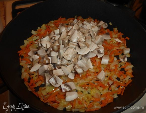 Первыми в зажарку отправляем сырые шампиньоны и обжариваем их с овощами несколько минут.