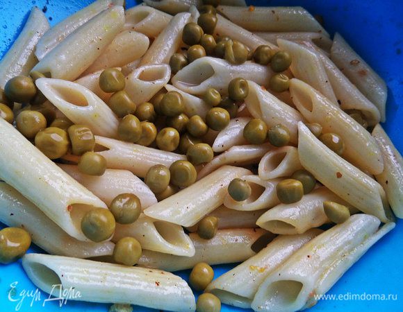 Начинаем смешивать салат. К пенне высыпаем горошек.