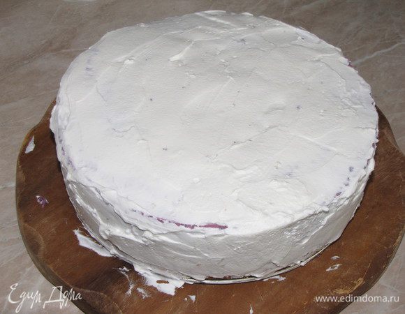 Взбить оставшиеся сливки, постепенно добавляя сахарную пудру, и обмазать торт со всех сторон.