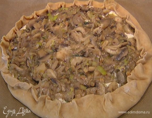 Отступая от краев лепешки на 2 см, равномерно распределить творожную массу, сверху выложить теплые грибы с луком, края теста загнуть на начинку и прищипнуть.