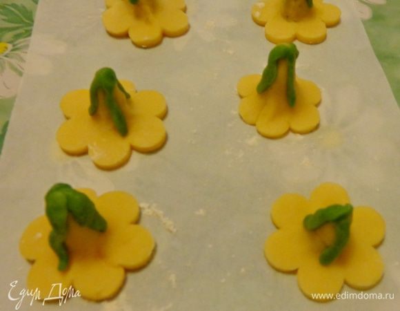 Из зеленого теста слепить листики и приложить их к бутонам.