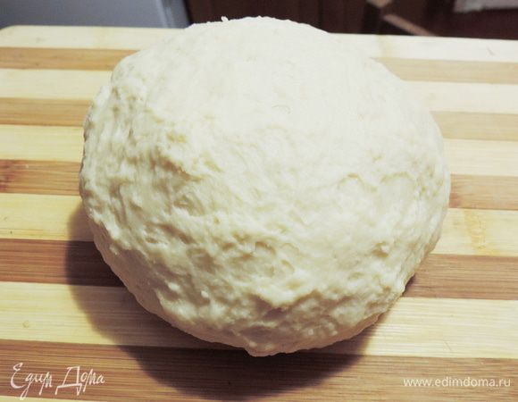 Вымесить мягкое тесто. Месить тесто до тех пор, пока оно не перестанет липнуть к рукам. Собрать тесто в шар, накрыть сухим чистым полотенцем и оставить на полчаса.