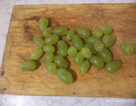 Виноград без косточек вымыть, оторвать ягоды от веточек, разрезать каждую виноградину пополам.