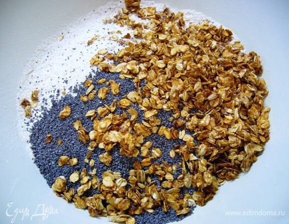 Муку с содой просеять. Смешать муку с содой, льняную «кашицу», карамелизированные хлопья (они могут слипнуться, раскрошить их руками), сахар, мак, влить апельсиновый сок. 