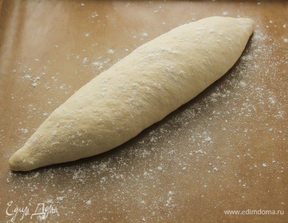 Раскатываем равномерно, утончая концы. Накрываем пленкой и оставляем расстаиваться швом вниз 45-60 минут, до двойного объема.