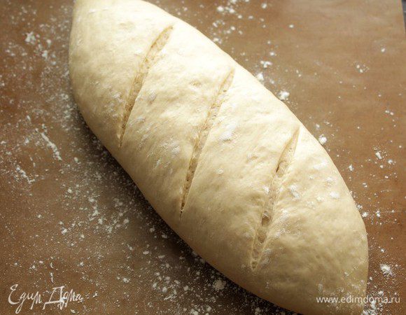 Разогреваем духовку до 230 градусов, на буханке делаем пару разрезов.