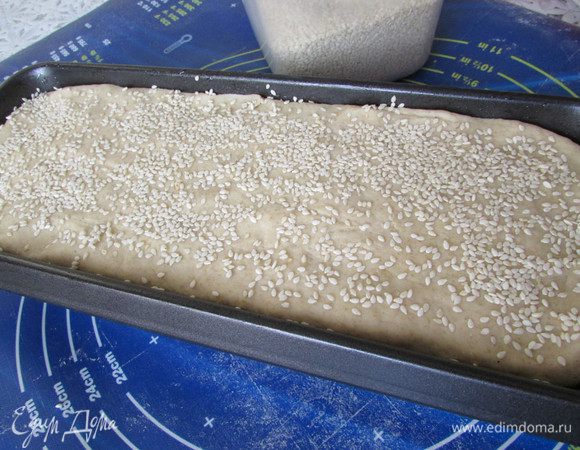 Смазать растительным маслом форму для выпекания хлеба. Выложить готовое тесто. Верх смазать растительным маслом и посыпать кунжутом. Накрыть салфеткой и оставить в теплом месте на 1 час для подъёма.