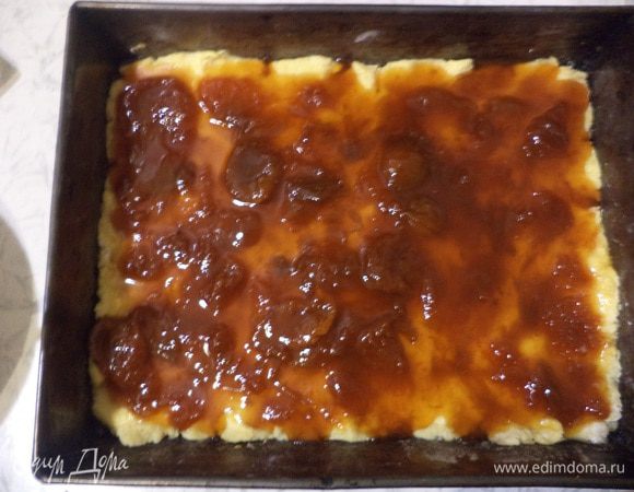 Тесто раскатать в прямоугольный пласт, выложить в смазанный маслом противень. 
Намазать тесто вареньем, а сверху на варенье выложить слой орехово - кокосовой массы.