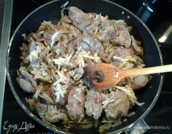 К печени добавить очищенное и натёртое на крупной тёрке яблоко. Перемешать и тушить 3 - 4 минуты.