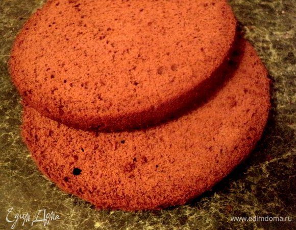 Готовый бисквит охладить на решетке. Его желательно испечь заранее и выдержать в холодильнике 5–6 часов, предварительно завернув в пищевую пленку. После этого бисквит хорошо режется. Бисквит разрезать на 2 пласта.