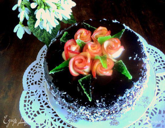 Соединить в сотейнике все ингредиенты для глазури и, постоянно помешивая, довести до кипения. Снять глазурь с огня и немного охладить. Торт вынуть из формы, установить на решетку и залить сверху глазурью. Также глазурью смазать бока торта и обсыпать кокосовой стружкой. Поставить торт в холодильник для застывания глазури. Затем украсить торт розочками из яблок, листиками из мармелада зеленого цвета.