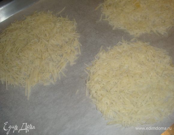 Готовим корзинки из пармезана. Пармезан трем на мелкой терке. Противень застилаем бумагой для выпечки. Приготовим несколько стаканов на которых будем делать корзинки. Рисуем круги, диаметром немного больше дна вашего стакана. Выкладываем 1-1.5 столовые ложки пармезана.