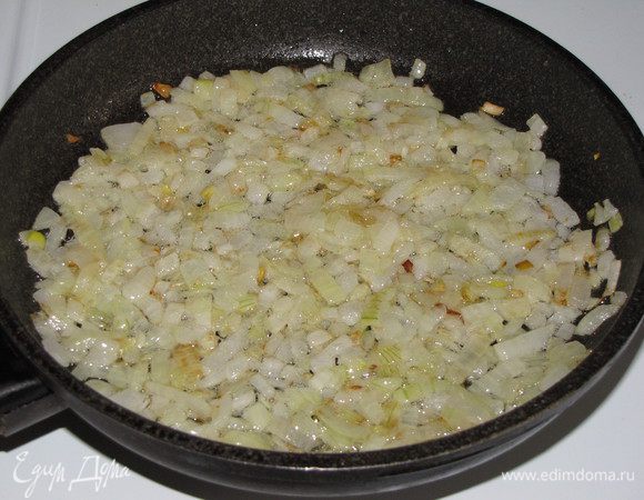 Разогреть в сотейнике или сковороде с высокими бортиками 4 ст. л. оливкового масла и обжарить на среднем огне мелко рубленный лук, помешивая, до золотистого цвета, 5-7 минут.