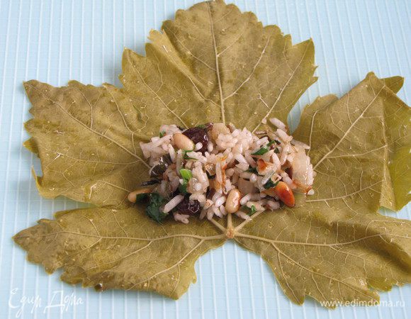Положите виноградный лист прожилками вверх, на основание листа, у черешка, немного отступив от края, положите 1 ст. л. начинки. 