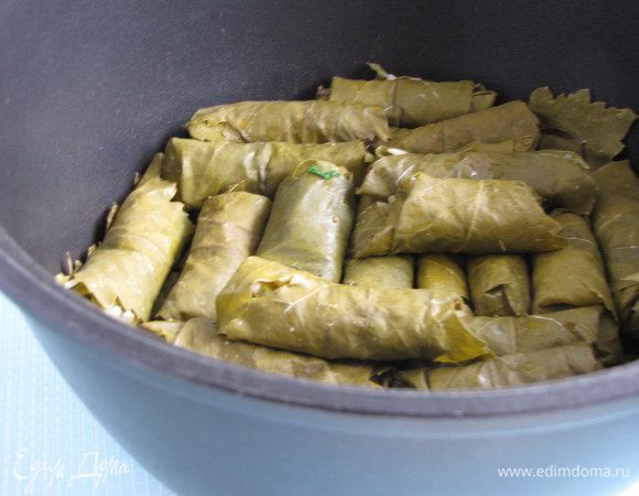 Дно сотейника выложите виноградными листьями, долму уложите плотно в сотейник в один или два ряда. 