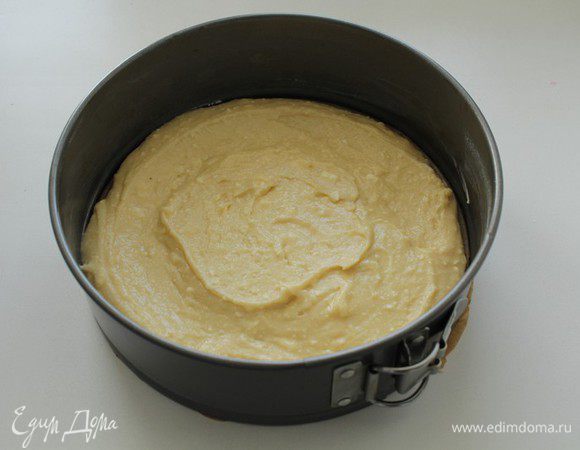 В форму (20см), проложенную бумагой для выпечки, выложить половину теста.