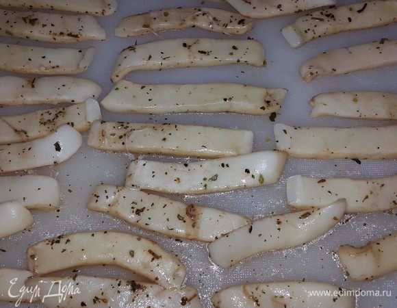 Кальмары достаем из маринада и режем на полоски.