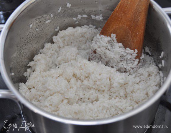 Растительное масло нагреть в толстостенной посуде на среднем огне. Засыпать и, помешивая, прогреть рис в течение 2 минут.
