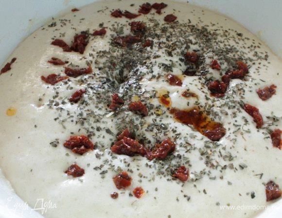 Вяленые томаты мелко нарезать, добавить к дрожжевой смеси, добавить одну или две чайные ложки сухого базилика. Добавить растительное масло. Я добавила одну ложку обычного растительного масла и две ложки масла от вяленых помидор. Перемешать.