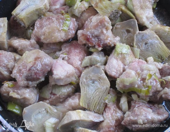 Через 2-3 минуты - артишоки. Обжарить 5 минут. Влить вино и готовить до испарения алкоголя. Посолить и поперчить по вкусу. Накрыть крышкой и готовить 25-30 минут, подливая бульон по необходимости.