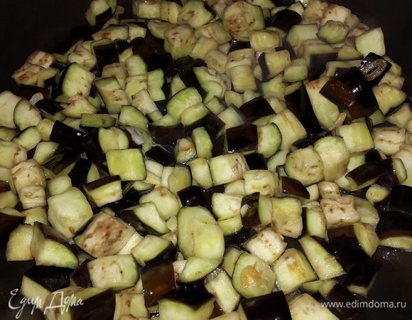 Баклажаны промываем под проточной водой и откидываем на дуршлаг.
На оливковом масле обжариваем сначала чеснок 2-3 минуты, затем добавляем баклажаны и обжариваем на среднем огне 5-7 минут.