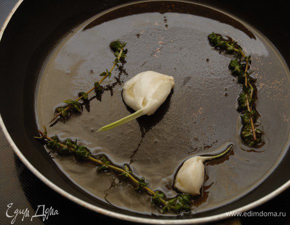 Широкой стороной ножа раздавить 2 зубчика чеснока. На масле от вяленных томатов слегка обжарить чеснок и 2 веточки тимьяна до характерного запаха, после чего удалить их из сковороды.