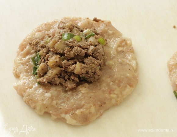 Из фарша формуем лепешку смоченными в холодной воде руками. На середину выкладываем начинку. Формовать удобней на ладони. Можно и на доске, но тогда ее надо смочить холодной водой, так как куриный фарш липкий.