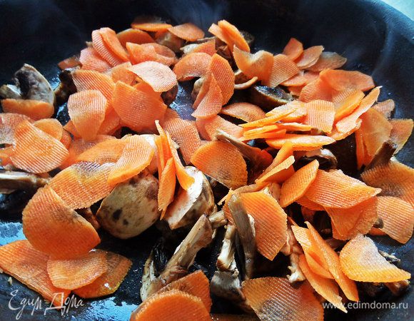Морковь и грибы обжариваем в вытопившемся жирке от салями сразу, не выключая огня.