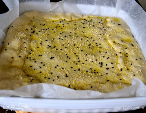 Раскатать оставшееся тесто, накрыть им пирог и скрепить края. Смазать пирог сверху немного оливковым маслом и посыпать кунжутом (у меня белый и черный кунжут).
