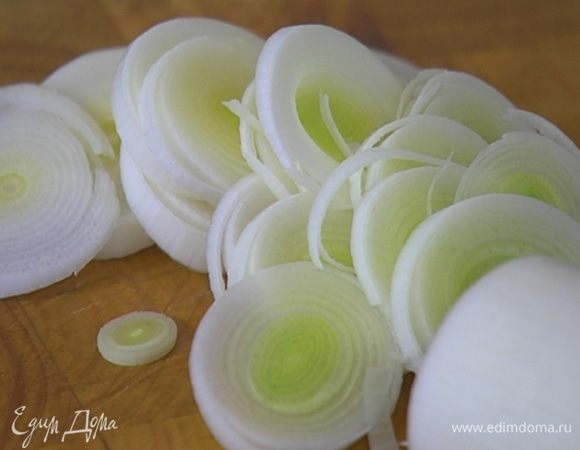 Светлую часть лука-порея нарезать тонкими кольцами.