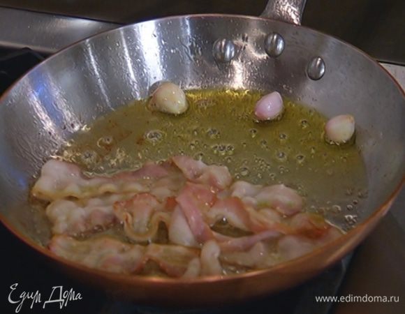 Чеснок почистить, выложить в сковороду с беконом и обжарить.