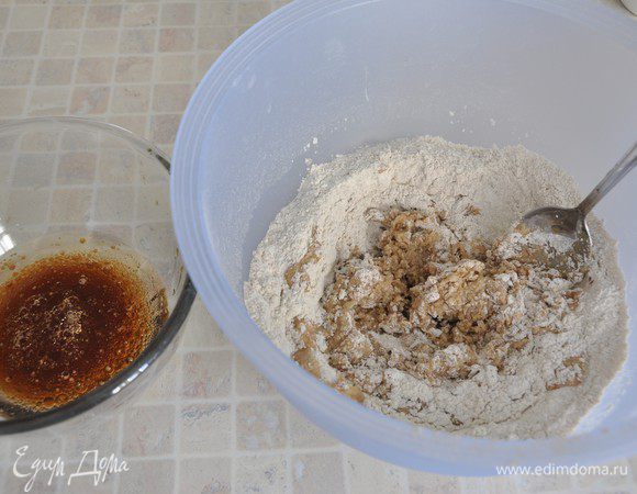 Добавлять жидкую часть в муку, ложкой замешивая тесто. Если тесто будет слишком мягким, добавить еще муки. Мне понадобилось добавить еще 2 столовых ложки муки (я добавляла ржаную).
