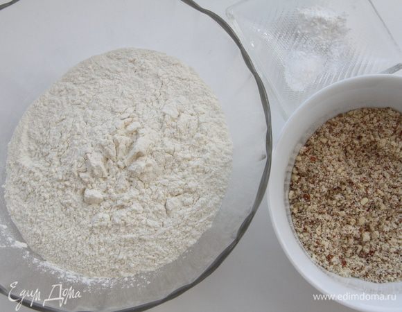Муку просеять вместе с разрыхлителем, орехи размолоть в блендере.