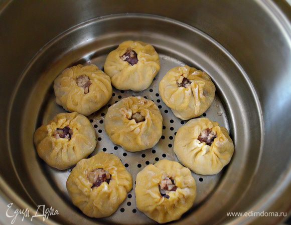 Теперь каждый бууз обмакиваем донышком в растительное масло и выкладываем в наполненную водой буузоварку (пароварку). Закрываем крышкой и готовим около 30 минут.