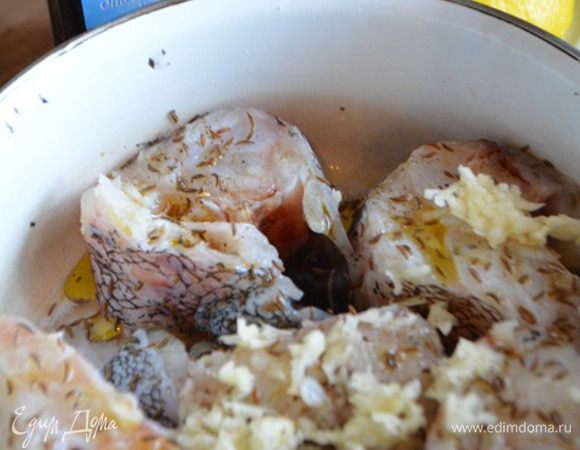 Рыбу разморозить, срезать плавники, помыть и обсушить бумажным полотенцем. Нарезать на порционные куски. Посолить.
Смешать маринад: оливковое масло, тмин, чеснок через пресс, перец свежемолотый, сок 0,5 лимона. Залить им рыбу и перемешать. Оставить мариноваться минимум 30 минут.