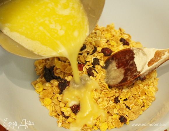 Смешать мюсли с растопленным сливочным маслом и 50 грамм сахарной пудры.