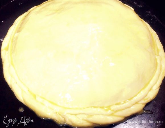 Раскатайте оставшееся тесто в тонкий пласт, уложите поверх начинки, поднимите края нижнего пласта, соедините с верхним, защипните края. Смажьте пирог яичным желтком. 