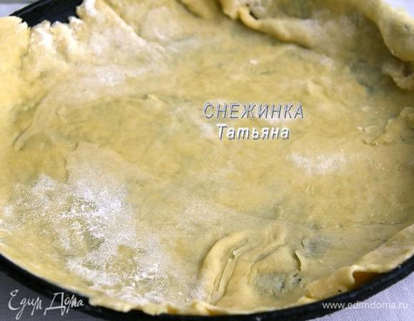 Делим нужное количество теста на три равные части. Раскатываем один корж, присыпая рабочую поверхность мукой. Раскатываем корж  размером чуть больше диаметра формы, в которой будем собирать торт, так как он немного деформируется, а лишние концы потом подрежем и они пойдут для украшения готового торта.