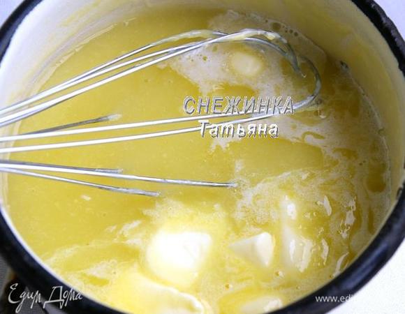 В другой кастрюльке растираем желтки с крахмалом, чтобы не было комочков. Ещё горячую лимонную жидкость вливаем к яичной. Быстро растираем венчиком. Ставим на огонь, постоянно помешивая венчиком, доводим сначала до кипения и кипятим на очень маленьком огне до загустения. Сразу же добавляем маленькими кусочками сливочное масло, перемешиваем.