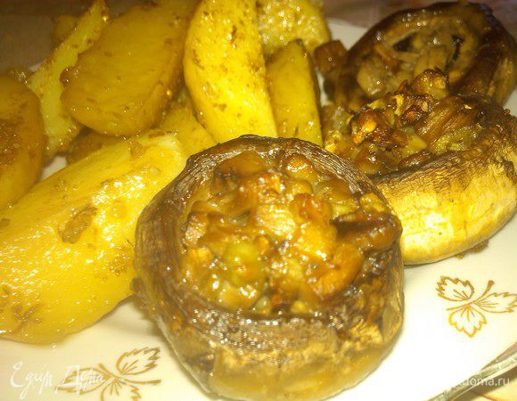 Выкладываем смесь в грибные шляпки. Далее картофель выкладываем в центр противня, грибы по окружности, картофель сверху сбрызгиваем маслом и посыпаем кориандром. Отправляем в духовку минут на 30-40 при 200 градусах. Пару раз духовку открываем и картофель перемешиваем.