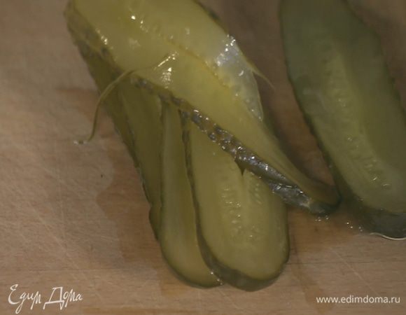 Маринованный огурец нарезать вдоль тонкими полосками.